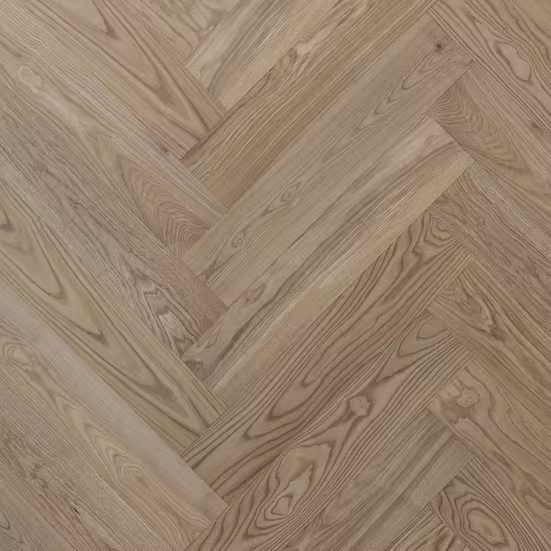 Honey-toned oak blocks laid in a herringbone pattern, the grain running in alternating diagonals.