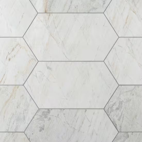 Elongated white marble hexagons set with fine grey grout, veined in soft grey and amber.